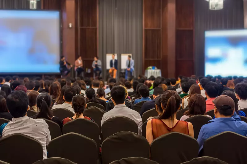 people in an auditorium listening to a lecture