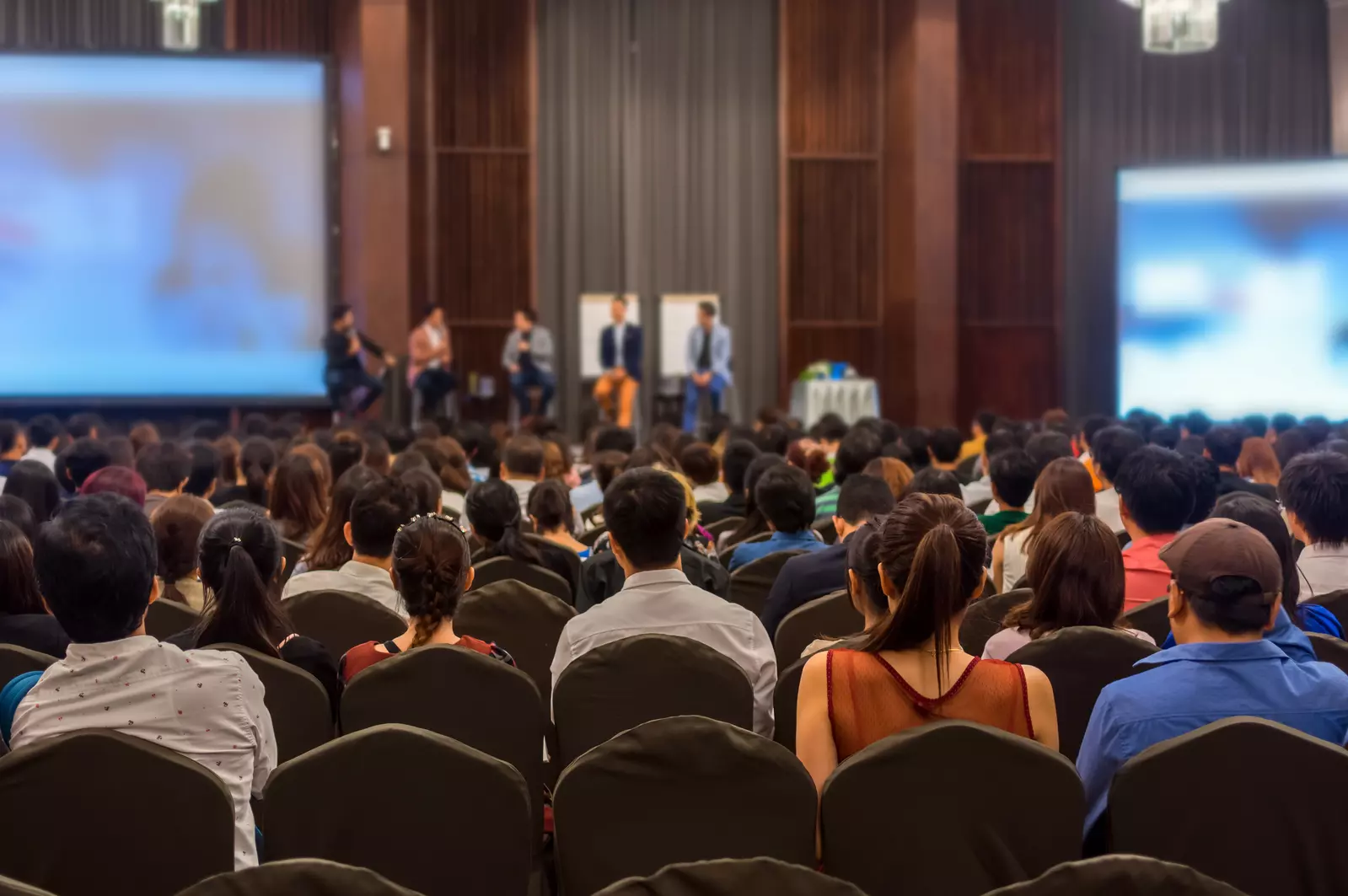 people in an auditorium listening to a lecture