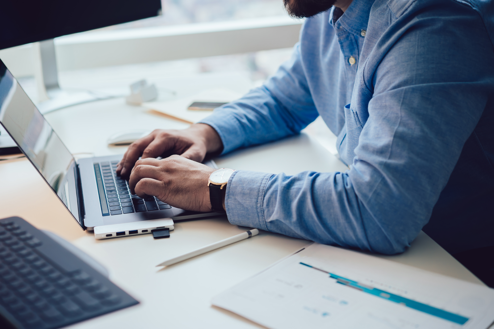 man typing on laptop in office