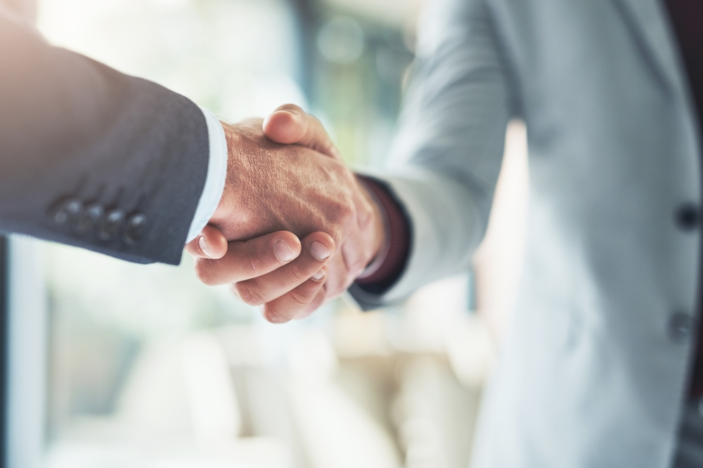 two men in suits shaking hands