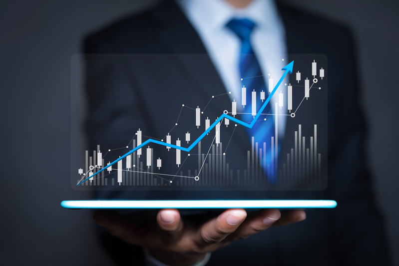 man in suit holding tablet with financial report graph