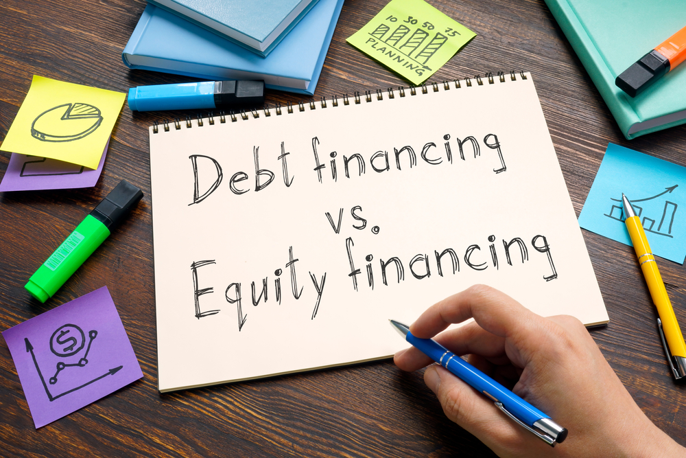 notbook with handwritten words Debt financing vs Equity financing