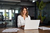 smiling woman working on laptop in office