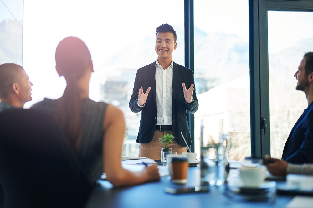 man giving sales pitch to group of people in meeting room