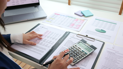 woman reviewing income statement with calculator